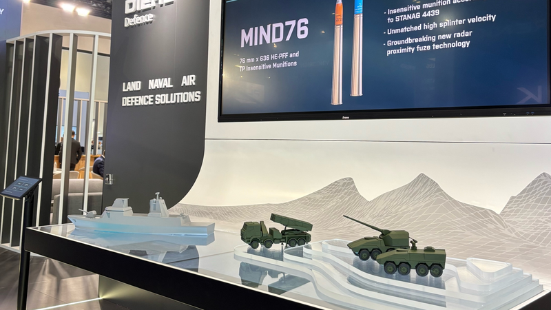 Bildschirme und Miniaturfahrzeuge kombiniert in einem Messestand.