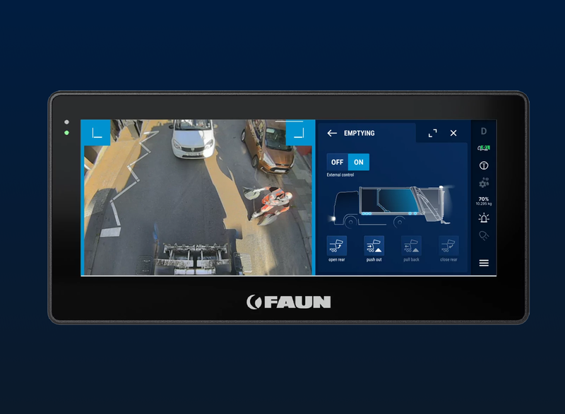 Ein Touchscreen-Display, auf dem das Bild einer Rückfahrkamera zu sehen ist, das eine Straße mit Fahrzeugen und einem Arbeiter zeigt, sowie Bedienelemente für die Entleerungsfunktion eines Müllwagens.