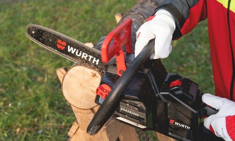 Eine Person sägt mit einem Akku-Säge Holz.