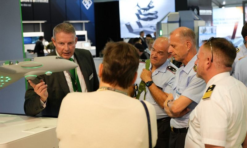 Eine Guppe an Menschen steht um ein Messemodel.