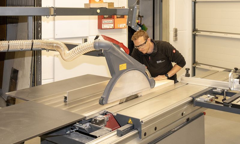 Mann steht an einer Kreissäge