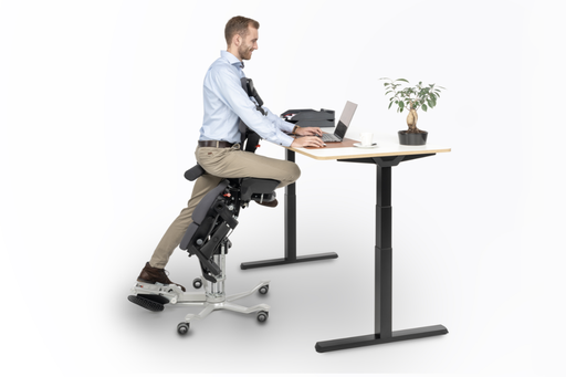 Mann sitzt ergonomisch am Schreibtisch