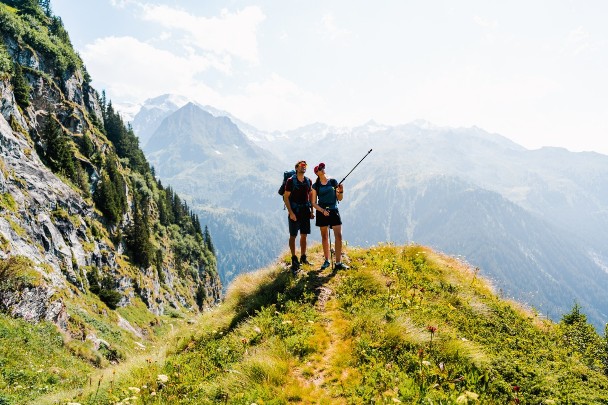 two hikers in verbier on a summers day pointing towards a trail