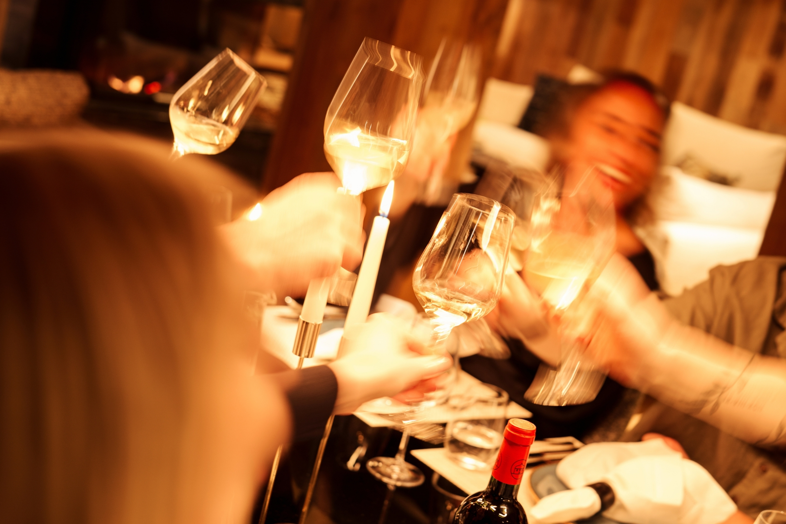 a group cheersing glasses in a luxurious chalet at night time