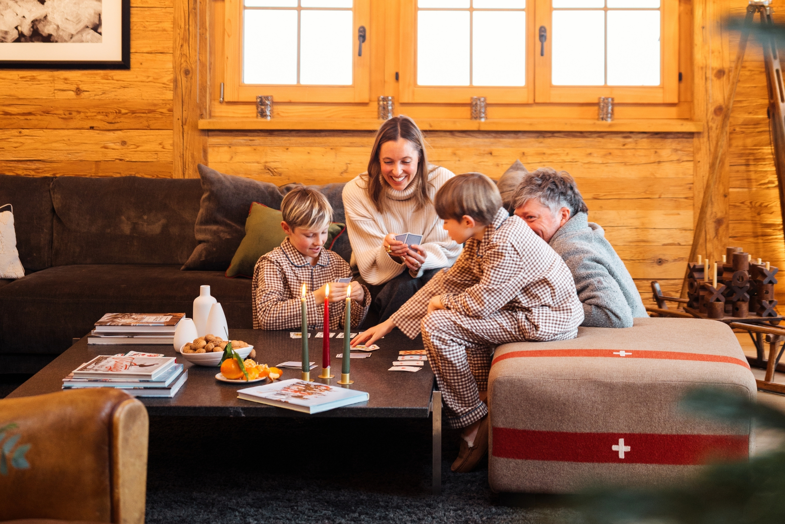A family play a game in a cosy ski chalet living room