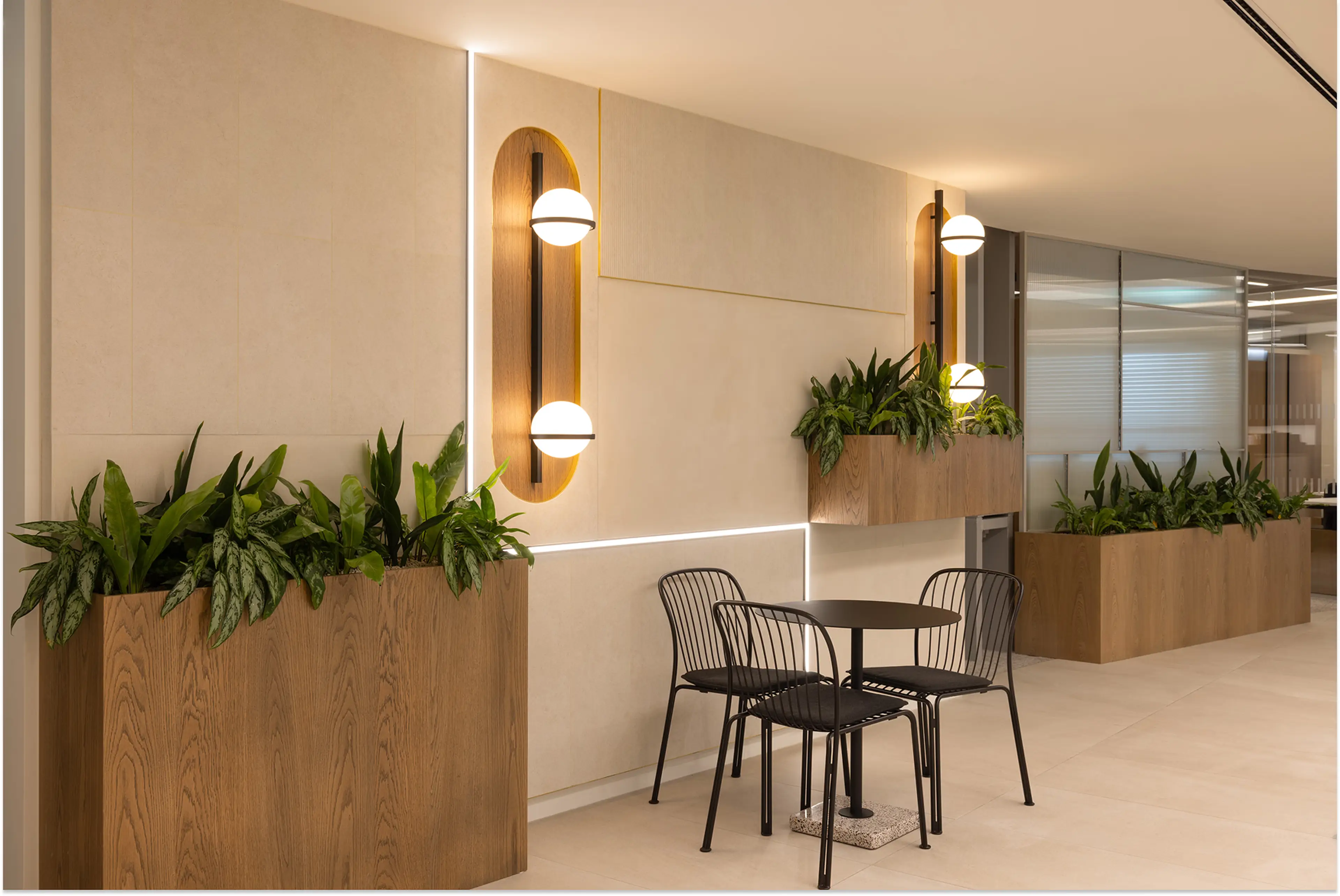 Hanging wall planters beside art deco lighting. Chairs and a table sit in the foreground