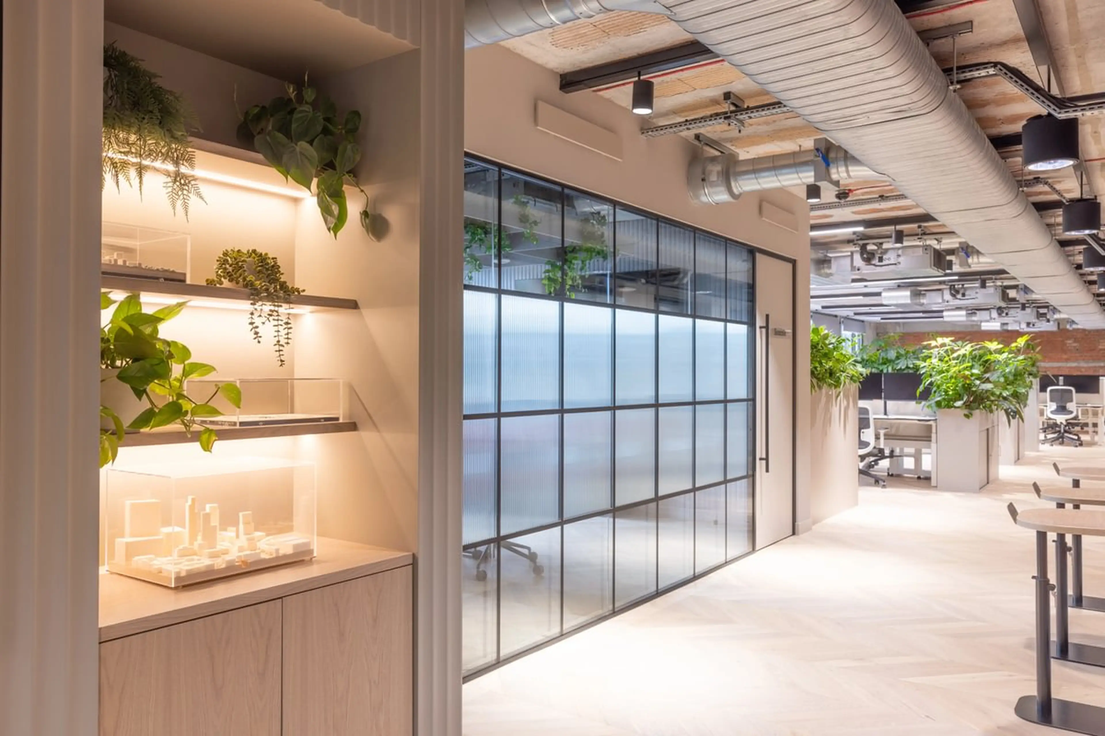 An office alcove with small wooden models, and hanging shelf office planting