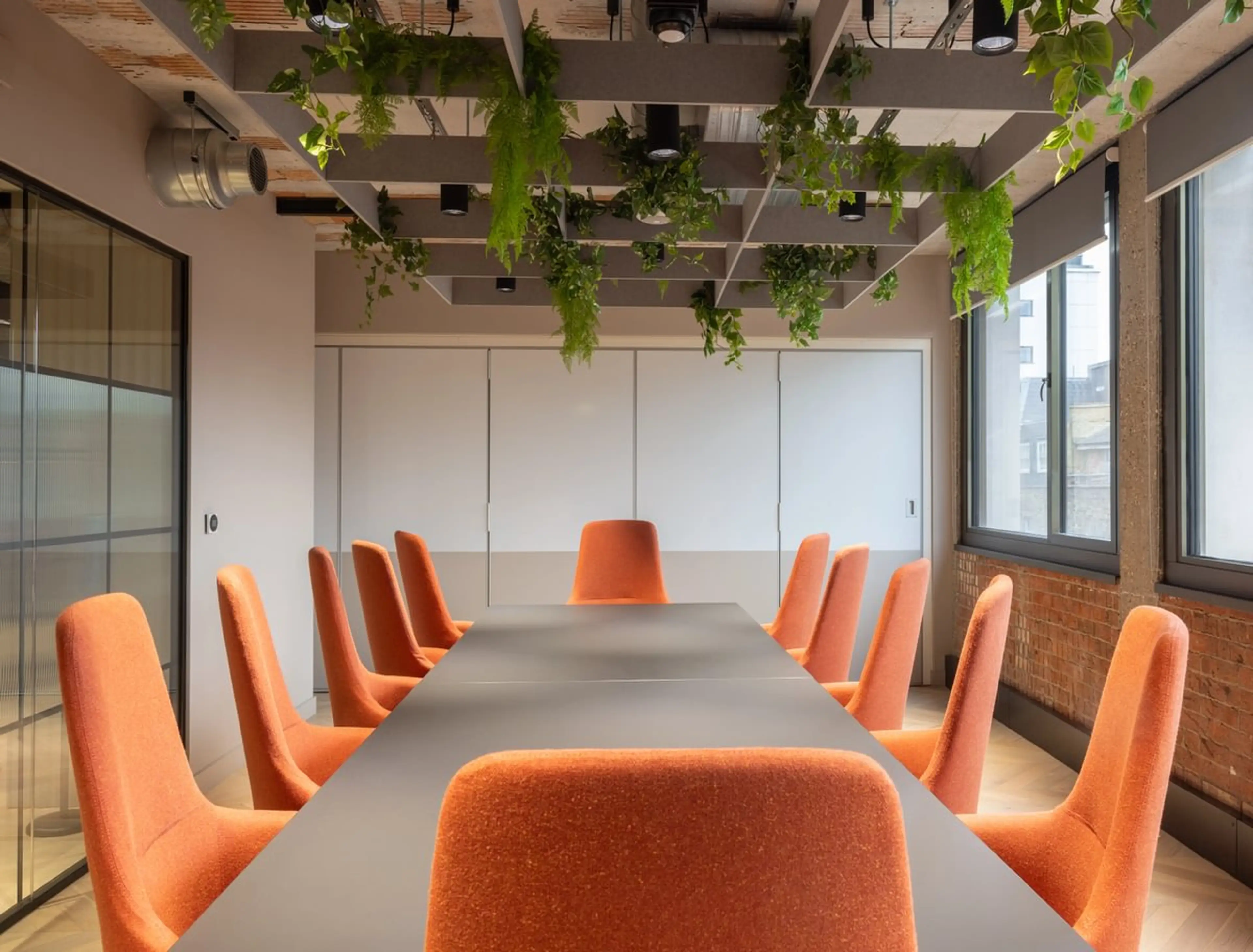 an office boardroom, with a hanging set of plants above the table