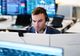 Copenhagen Merchants broker working at his trading desk with market screens in the background