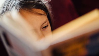Child intently reading a book