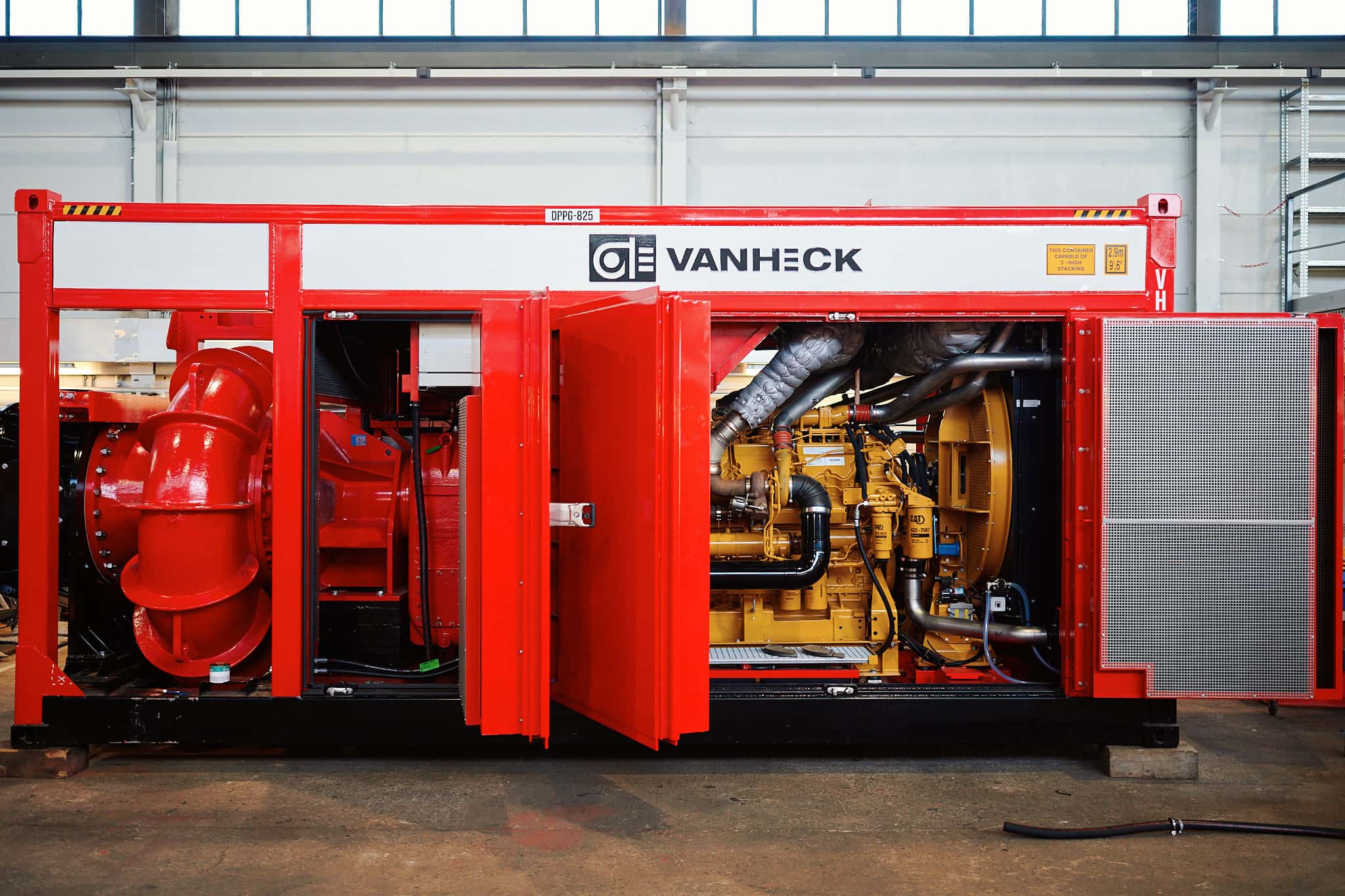 DPPG825 HK800 in de werkplaats Rode retourwaterpomp met open deuren, onthullend complexe apparatuur en leidingen binnenin, geplaatst in een werkplaats.