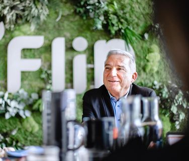 Älterer Mann vor grünem Flip Logo, modernes Büro, Mitarbeiterplattform, Mitarbeiter App.