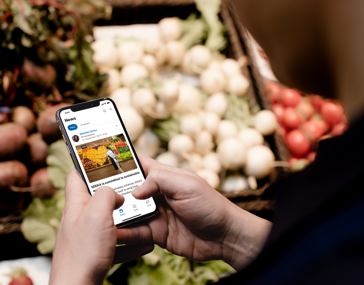 Employee uses Mitarbeiter App for news, HR-Portal, Employee Experience Platform at EDEKA store.