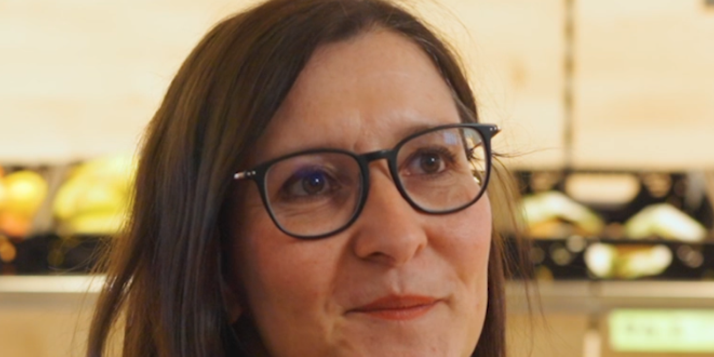 Woman zeigt Mitarbeiter App mit Flip Flows, HR-Portal, Mitarbeiterplattform im Supermarkt.