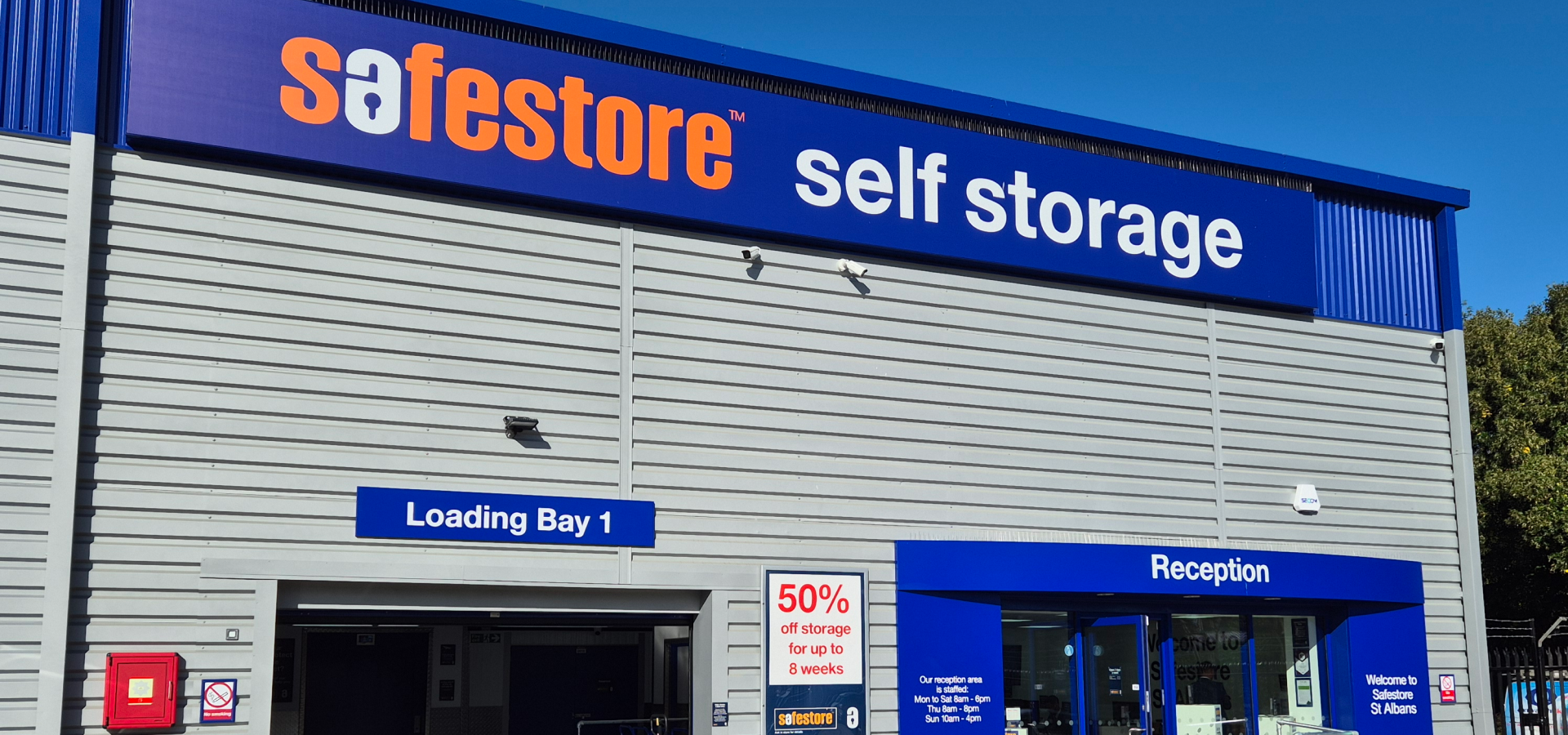 Safestore self storage building exterior with signs: Loading Bay 1, Reception, 50% off storage for up to 8 weeks.