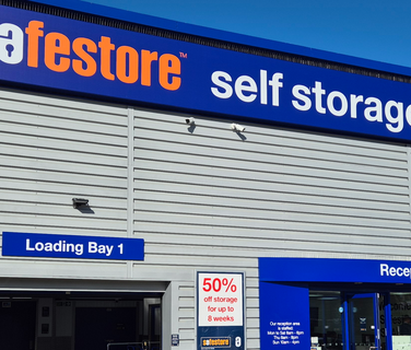 Safestore self storage building exterior with signs: Loading Bay 1, Reception, 50% off storage for up to 8 weeks.