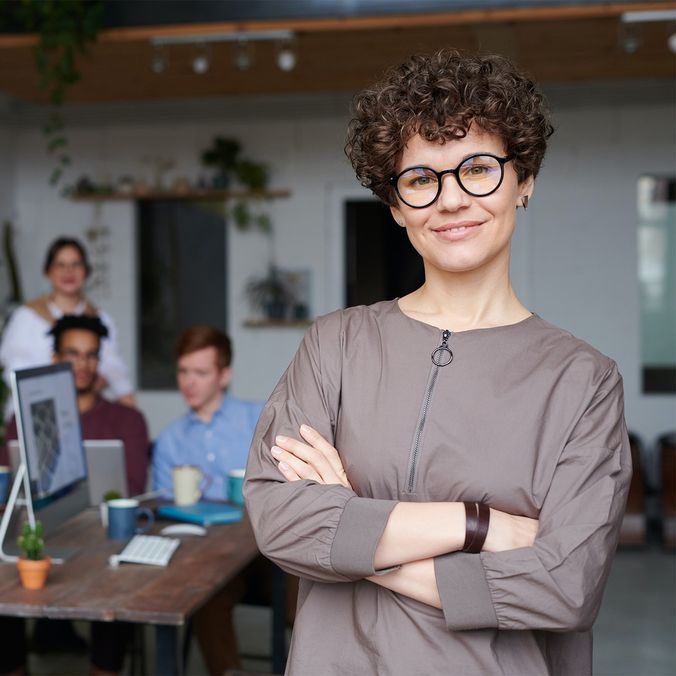 Team leader in modern office with diverse team collaborating at table, fostering employee engagement.