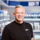 Man smiling in front of Europart shelves with products.