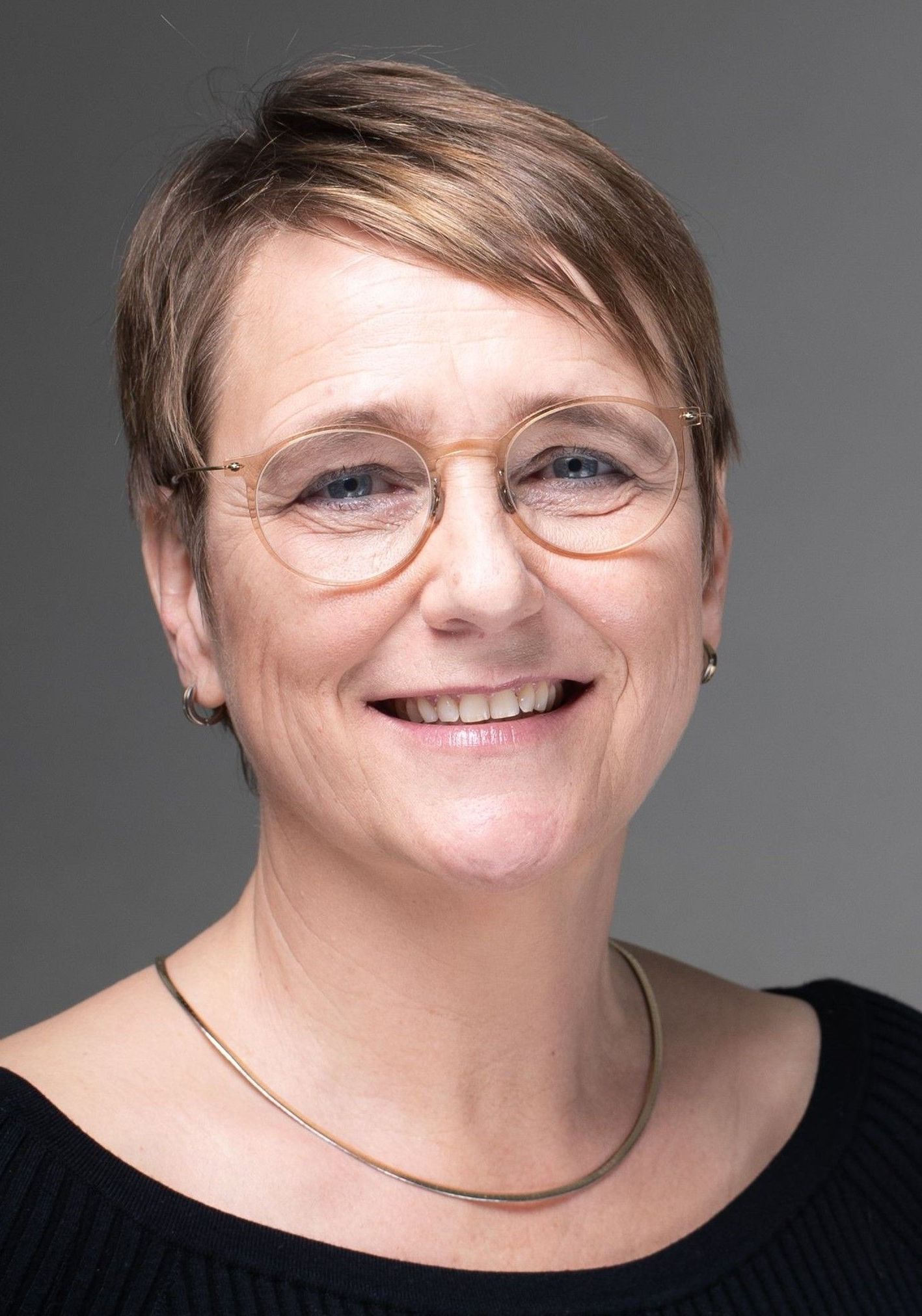 Smiling woman with short hair and glasses
