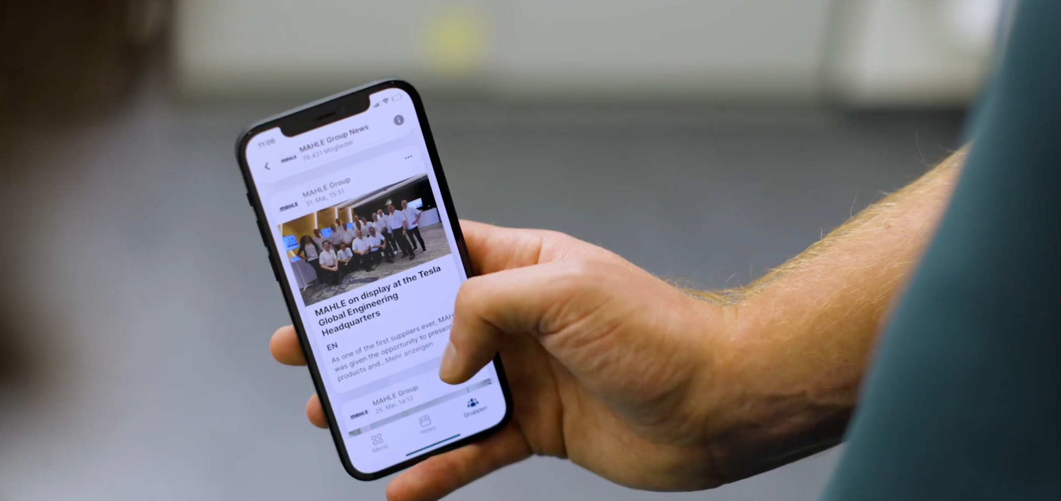 Person holding phone displaying MAHLE Group news