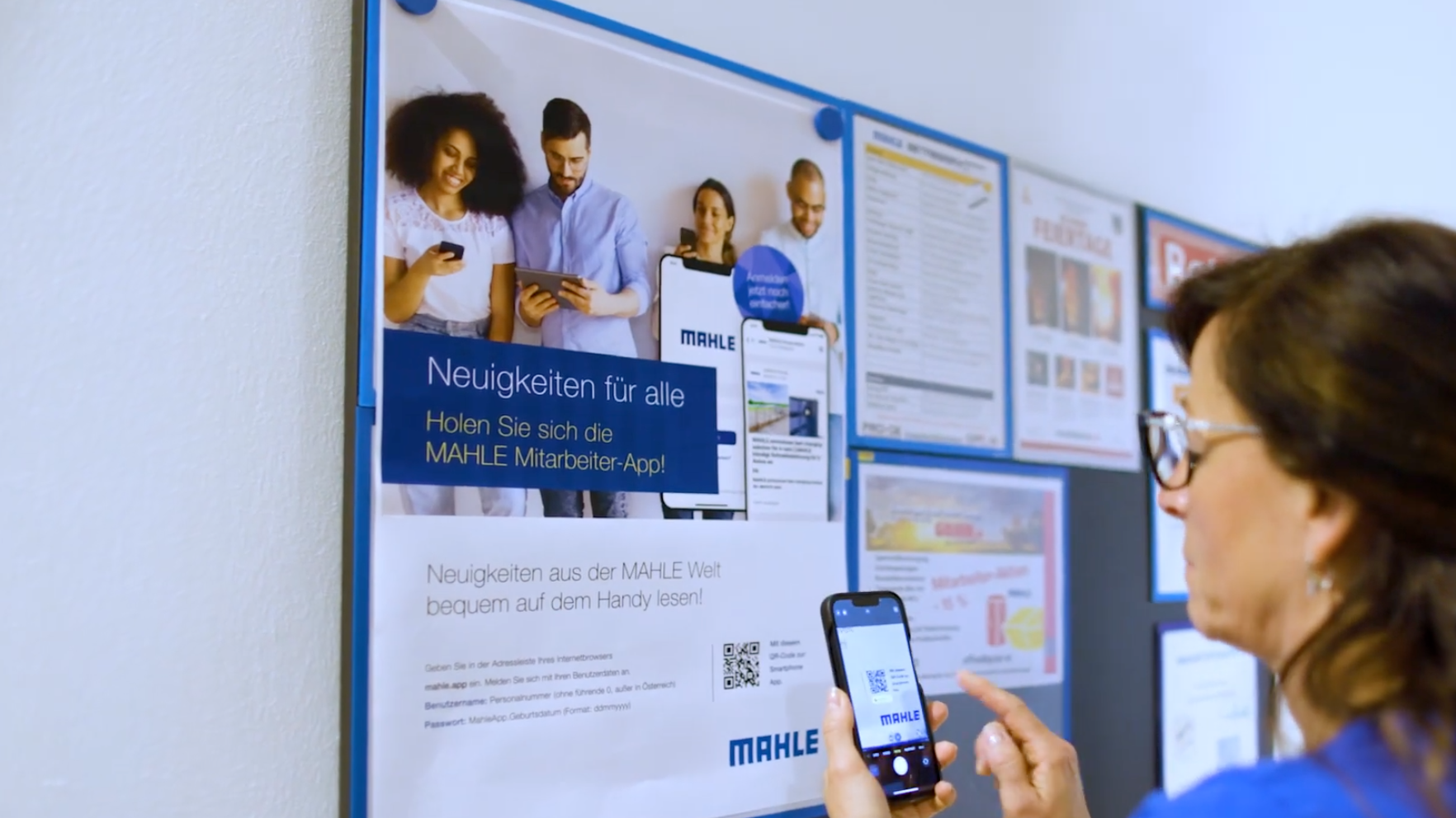 Person scans Mahle app QR code on a bulletin board.