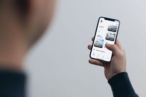 Person hält Smartphone mit deutscher App-Oberfläche.
