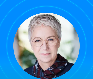 Person with short hair and glasses, framed by blue circles.
