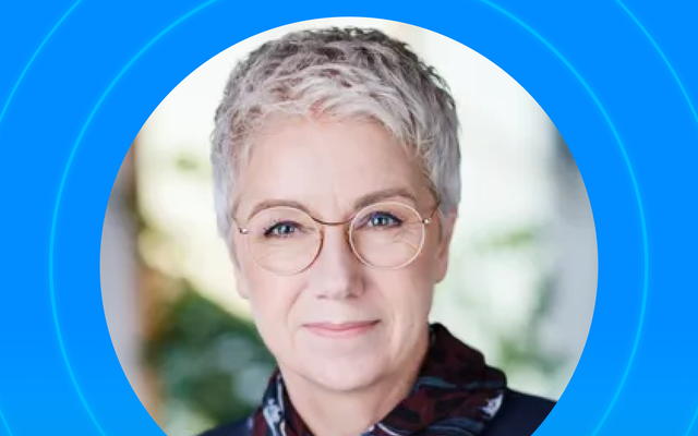 Person with short hair and glasses, framed by blue circles.