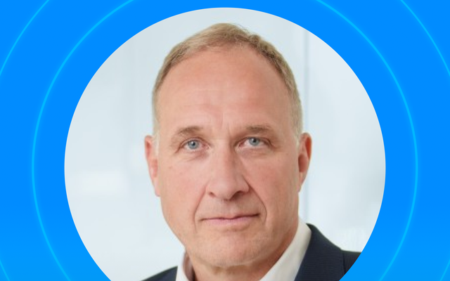 Portrait of a man against a blue circular background.