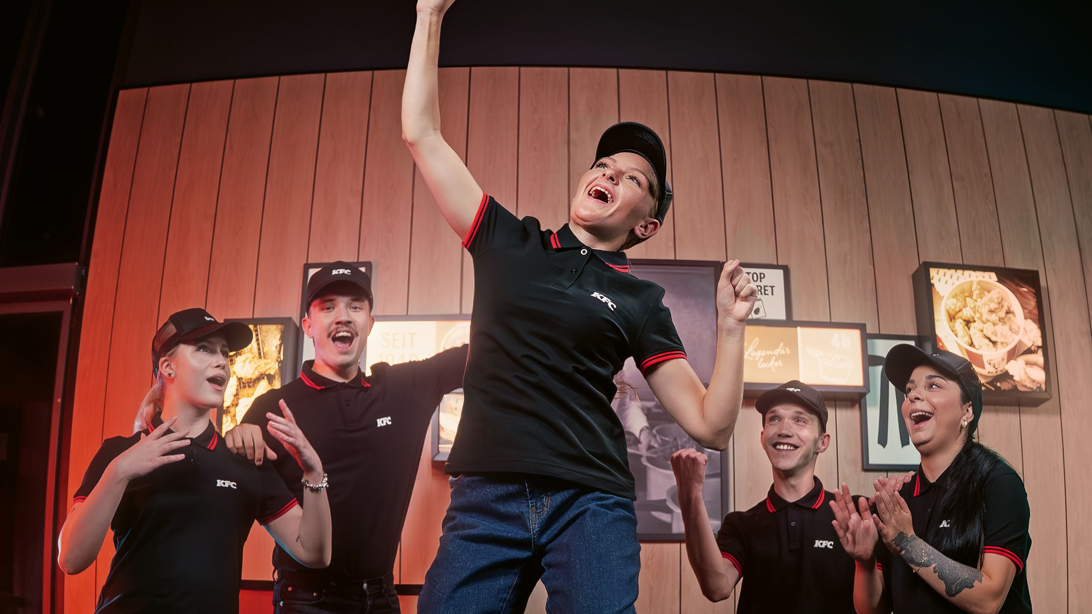 KFC employees celebrating with enthusiasm indoors.