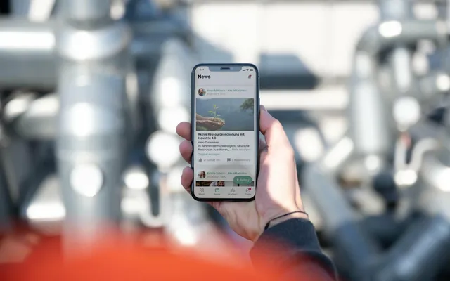 Hand hält Smartphone mit Flip Mitarbeiter App: News, HR-Portal, Mitarbeiterplattform, Employee App.