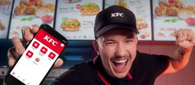 KFC employee excitedly showing a phone app at the counter.