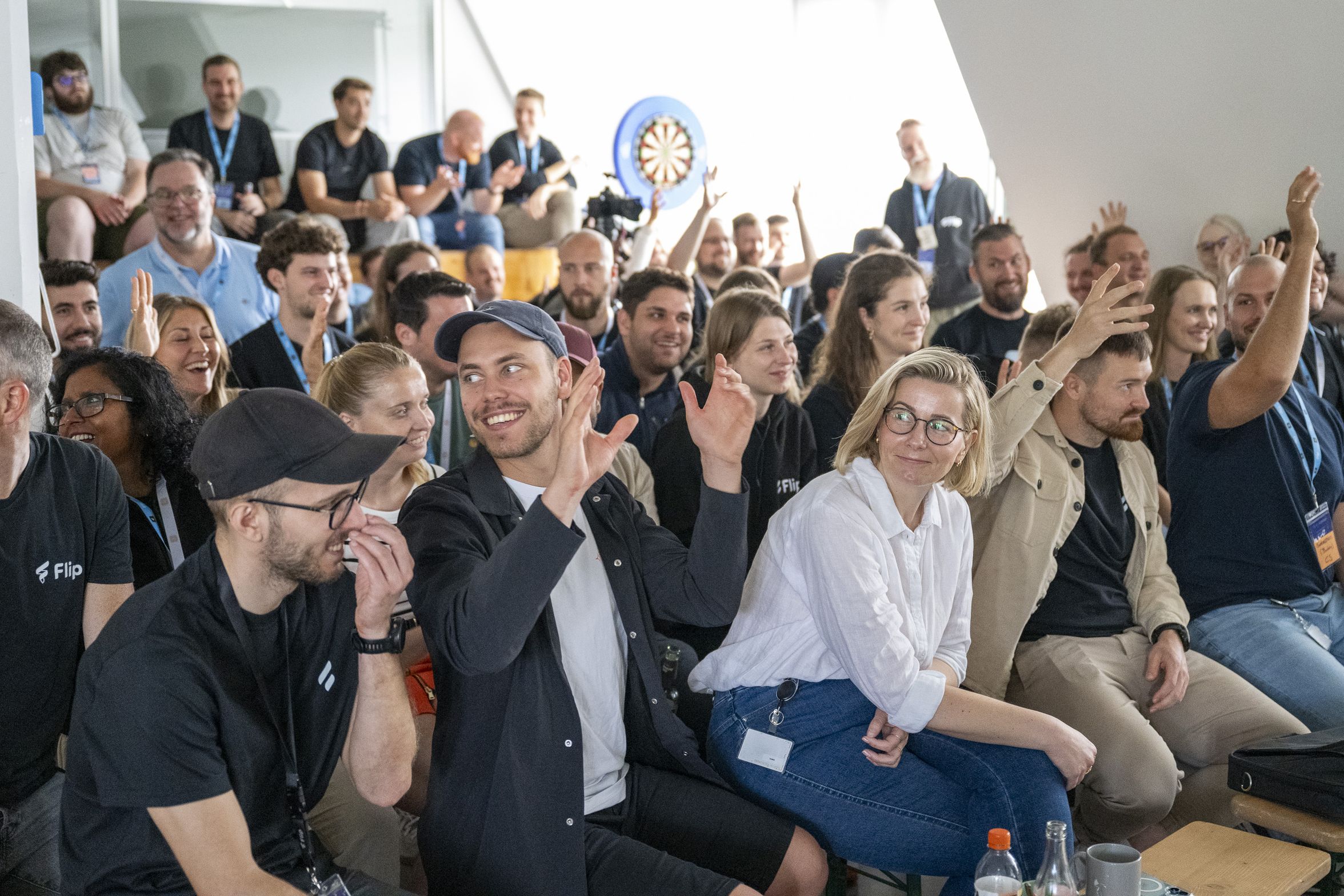 Group of people sitting and raising hands at an event.