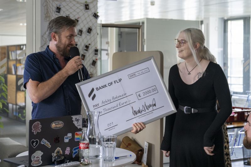 A man hands a giant check to a smiling woman.