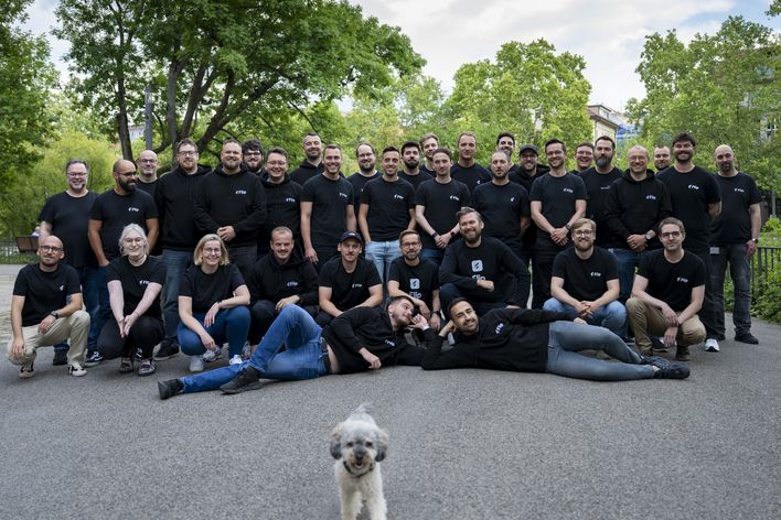A group photo of people in black shirts with Flip logos outside.
