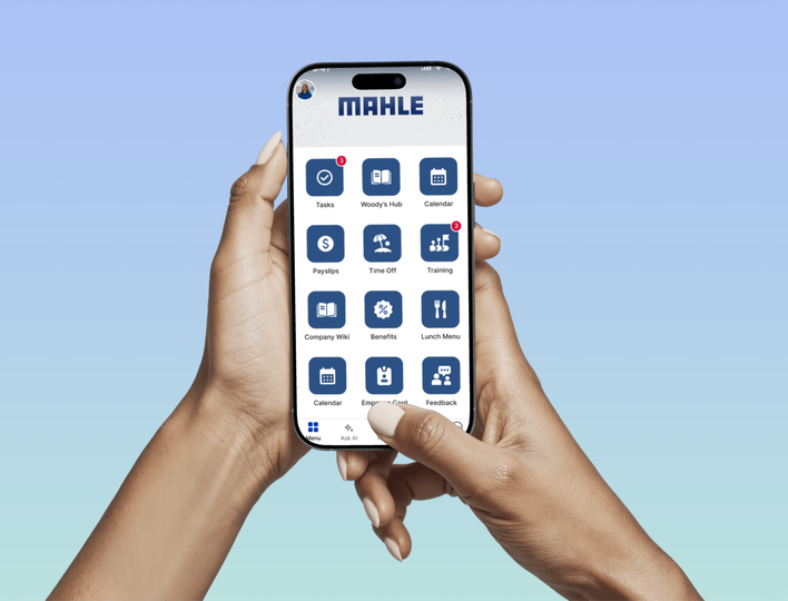 Hands holding a phone displaying Mahles HR app interface.