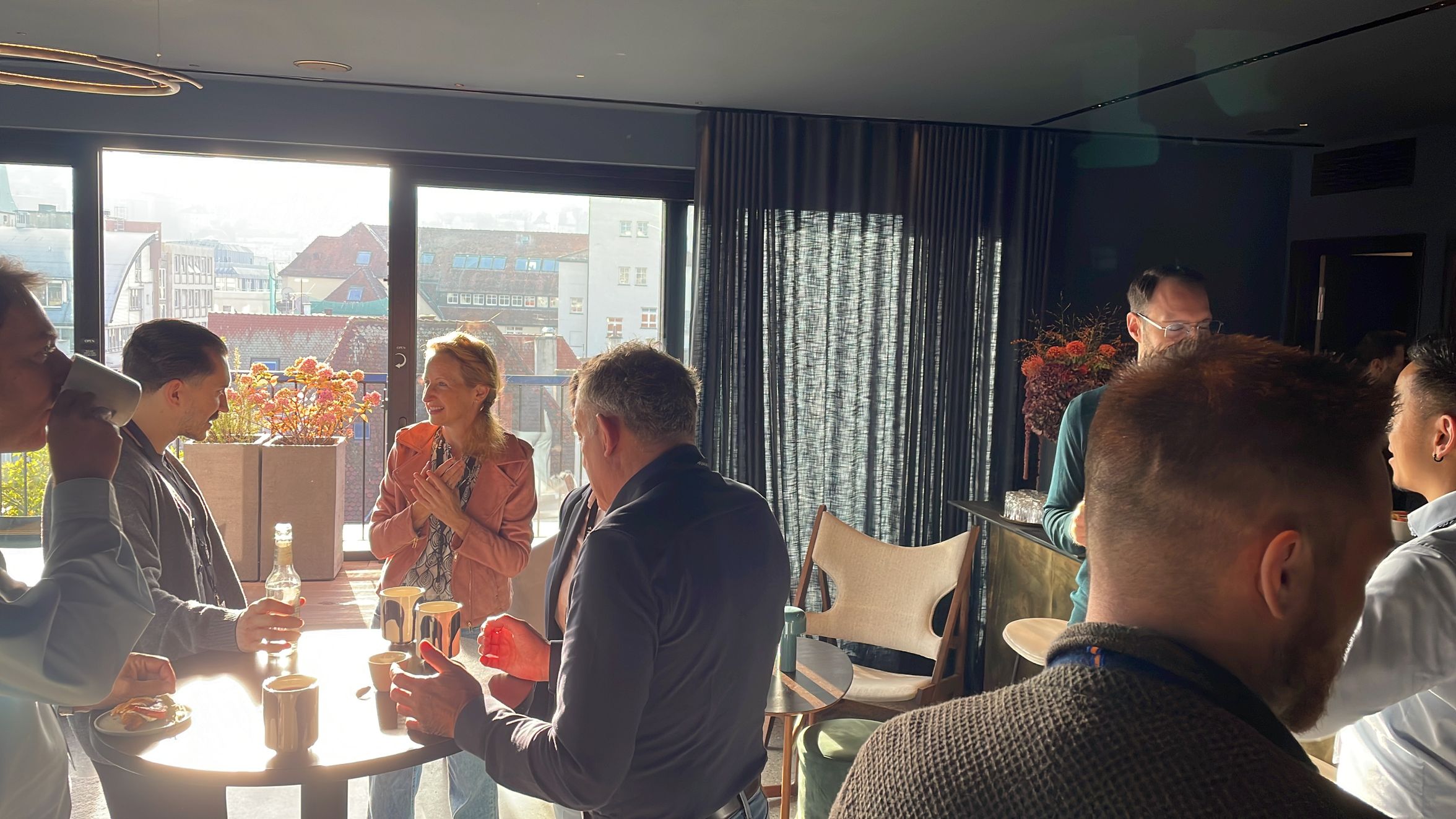 People networking at an indoor event with city view.