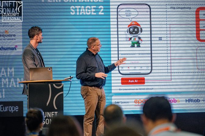 Two presenters discuss an AI interface at Zukunft Personal Europe.