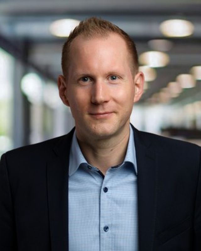 Portrait of a man in a suit in an office setting.
