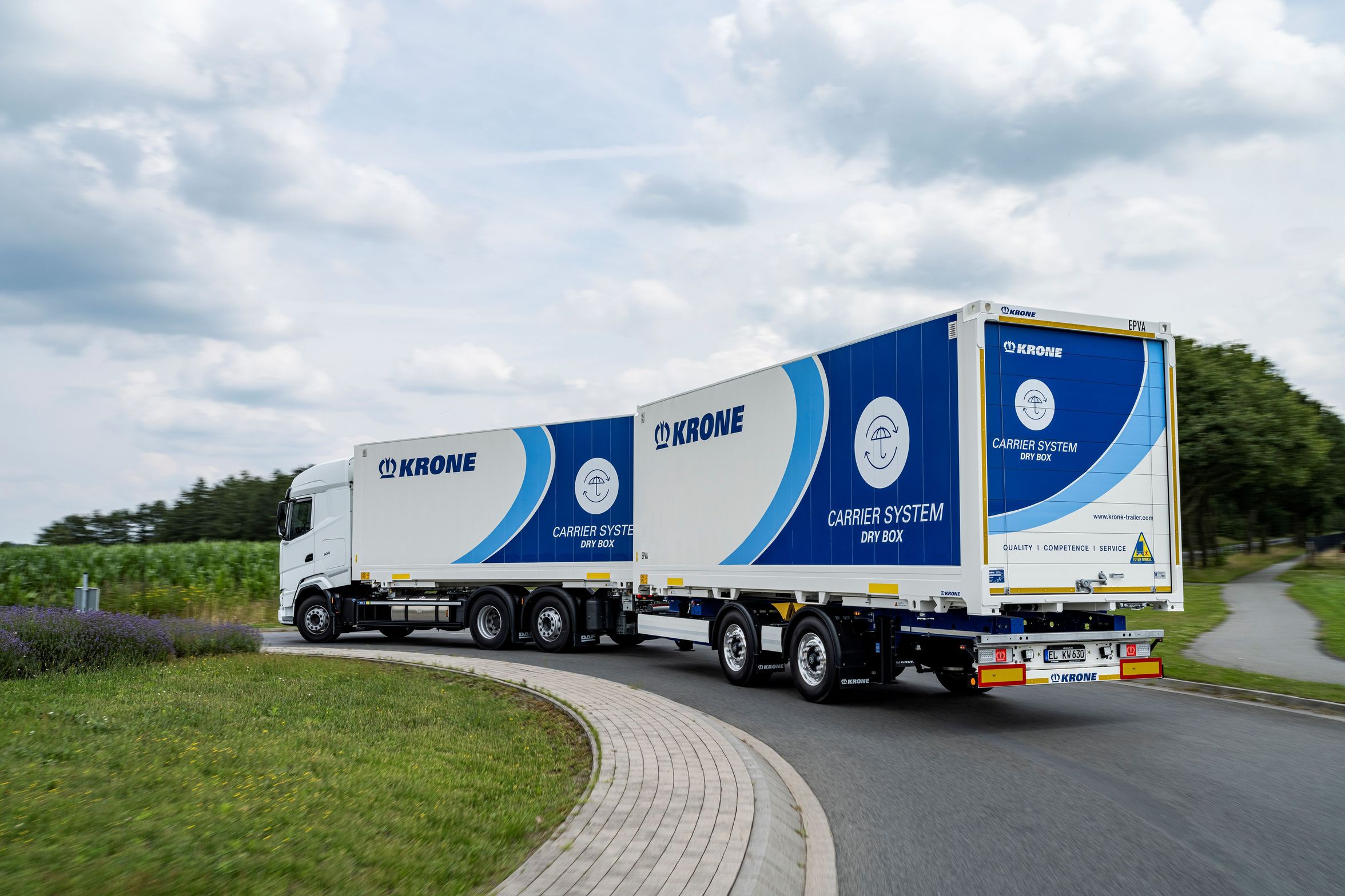 Truck with Krone Carrier System Dry Box on a road.