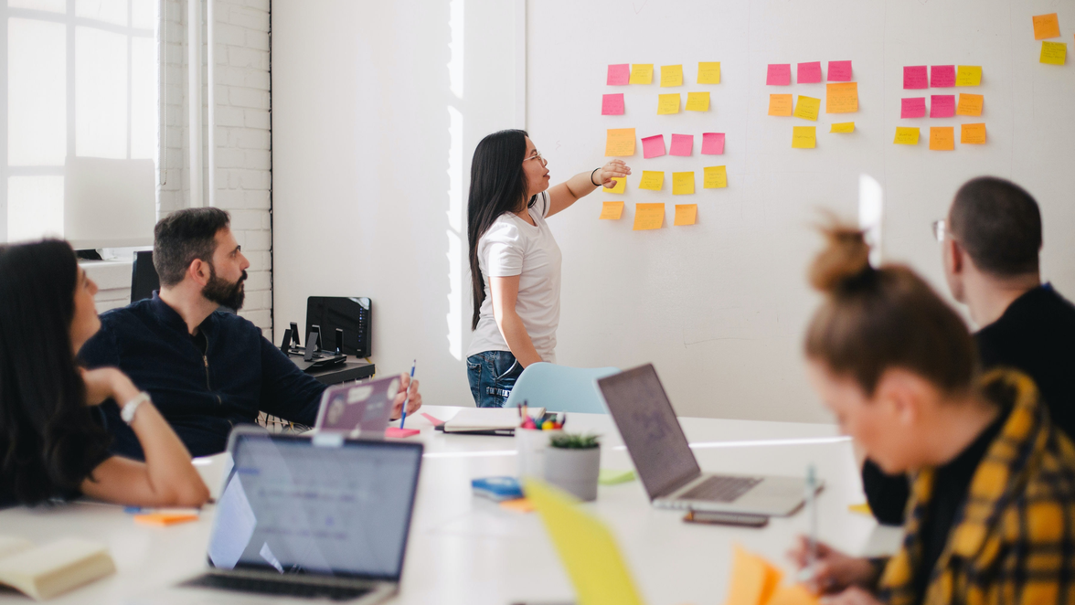 Team brainstorming with sticky notes on a whiteboard.