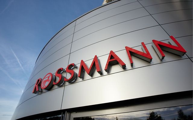Modern Bürogebäude mit großem ROSSMANN Schriftzug an der Fassade bei blauem Himmel.
