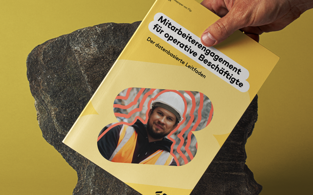 Hand hält Flip-Whitepaper „Mitarbeiterengagement für operative Beschäftigte“ vor gelbem Hintergrund.