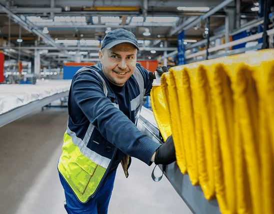 Male worker smiling in a manufacturing facility