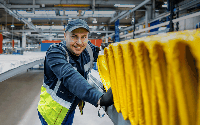 Male worker smiling in a manufacturing facility