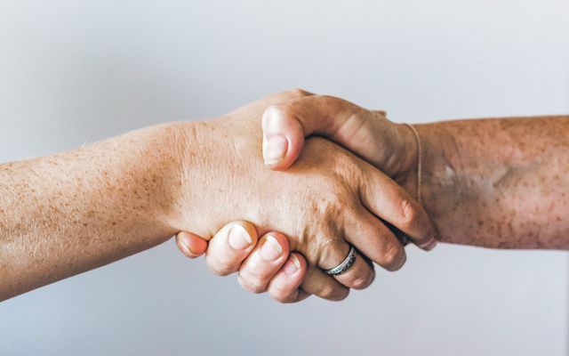 Two people shaking hands, symbolizing a Vertriebspartnerschaft or business partnership.