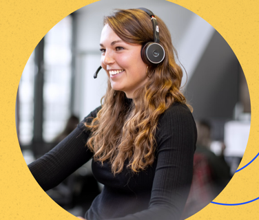Smiling woman with headset in office, symbolizing Employee App, Mitarbeiterplattform, HR-Software.