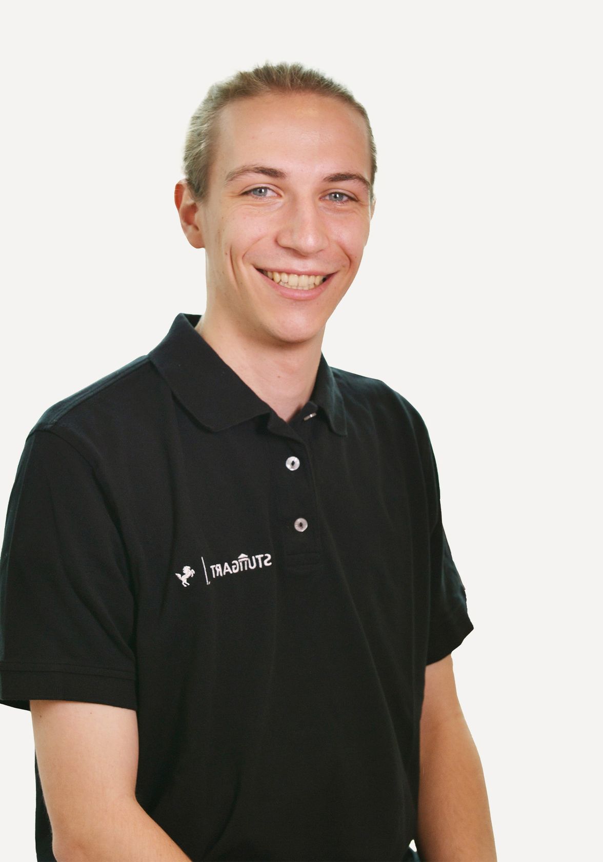 Junger Mann im schwarzen Stuttgart-Poloshirt lächelt vor weißem Hintergrund.