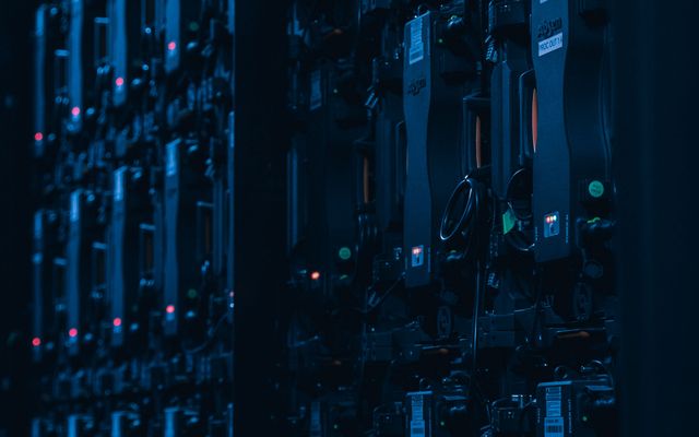 Close-up of server racks in a dimly lit data center, highlighting IT infrastructure.
