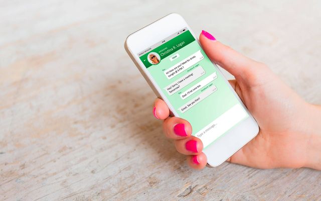 Hand holding smartphone with WhatsApp chat; internal communication, Mitarbeiter App, Employee App.